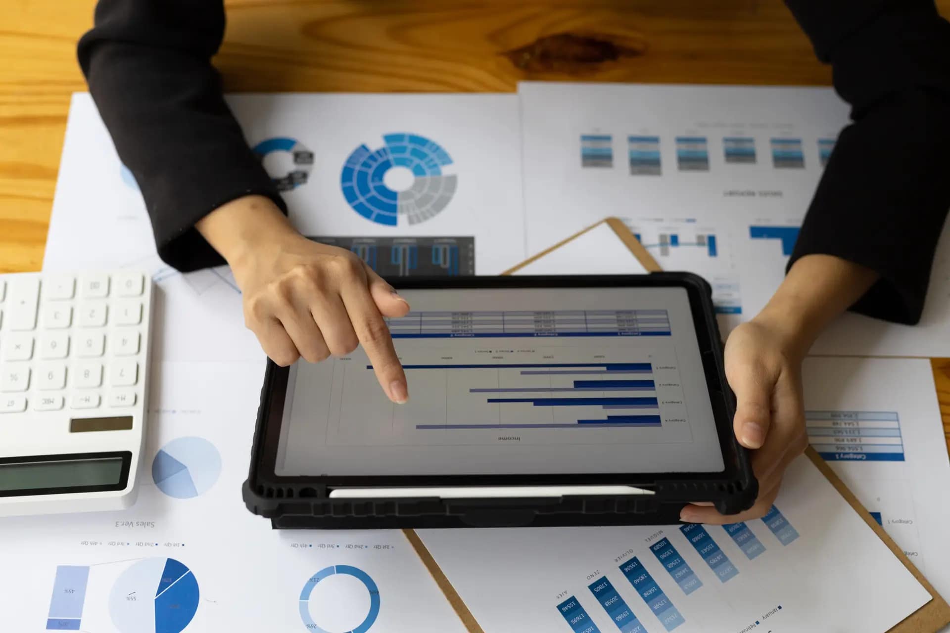 Businesswoman analyzing financial statistics displayed on the tablet screen, working data document graph chart report marketing research development planning management strategy accounting.